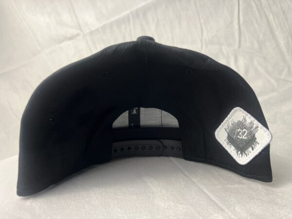 Direct back view of the Slash-32 9/50 Snapback hat, Black (Panda Mode) "We Will Resist" cap, highlighting the white diamond-shaped /32 microchip patch stitched in.