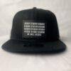 Front view of the Slash-32 9/50 Snapback hat, Black (Panda Mode) "We Will Resist" cap, displaying a black rectangle patch with binary code above the “We Will Resist” text.