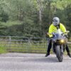 Image of a knøwn høst wearing the yellow FH0 – Knøwn H0st’s Binary Hoodie by Slash-32, actively driving a motorcycle, showing the custom binary signature on the hood.
