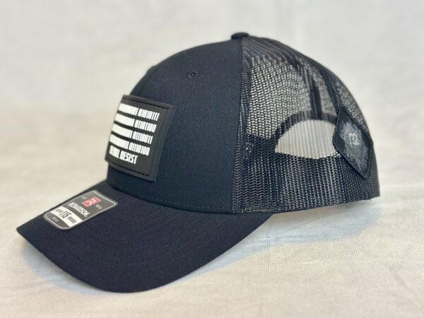 Image of Slash-32 Trucker Style Snapback hat - Black "We Will Resist" cap, side view showing both the front binary patch with “We Will Resist” and the /32 microchip patch on the side.