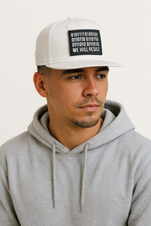 Image of a known host wearing the Slash-32 9/50 Snapback White cap featuring the black rectangular patch with binary code and “We Will Resist” text.