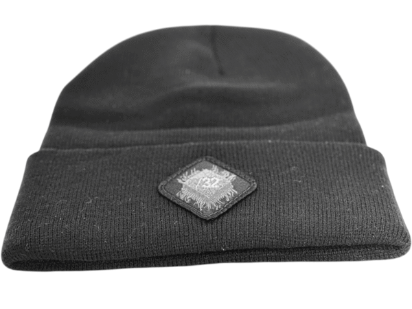 Image of the black “We Will Resist” rolled beanie by Slash-32 with a diamond-shaped patch featuring the /32 microchip symbol sewn in.