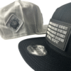 Image featuring a black Slash-32 9/50 Snapback hat with a black binary patch and a white fitted hat with a white diamond patch, both showcasing the /32 microchip emblem.