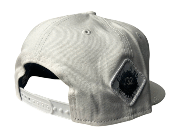 Side-back view image of Slash-32 9/50 Snapback hat, White showing the white diamond-shaped /32 microchip patch.