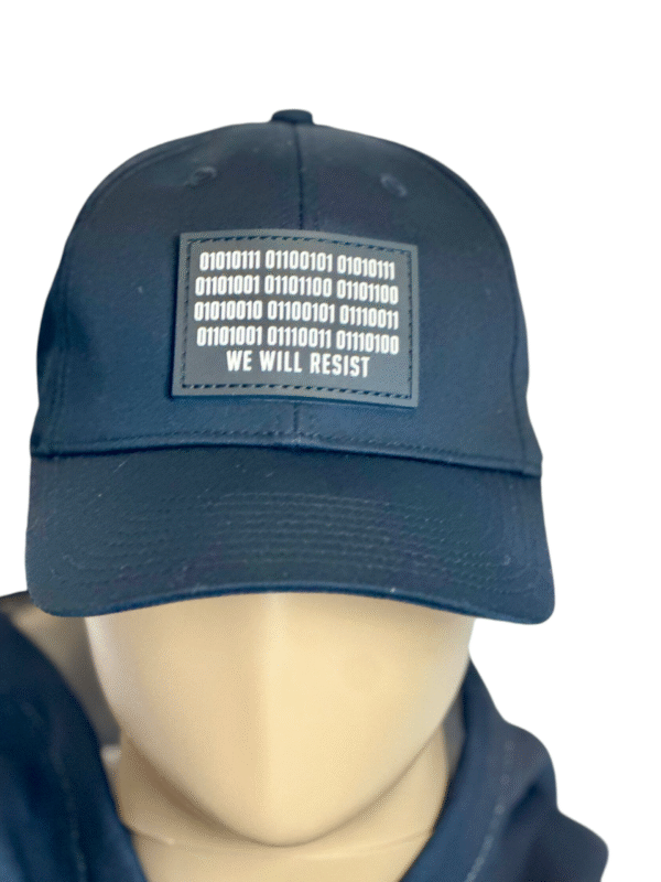 Image of Slash-32 Trucker Style Snapback hat - Black "We Will Resist" cap on mannequin, featuring a black rectangle patch with binary matrix and “We Will Resist” text on the front.