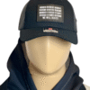 Image of Slash-32 Trucker Style Snapback hat - Black "We Will Resist" cap on mannequin, featuring a black rectangle patch with binary matrix and “We Will Resist” text on the front.