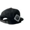 Side-back view of the Slash-32 9/50 Snapback hat, Black (Panda Mode) "We Will Resist" cap, featuring a white diamond-shaped patch with the /32 microchip emblem stitched in.