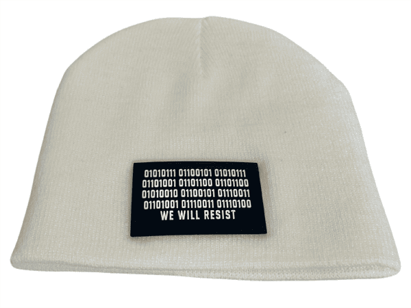 Front view of a white rolled beanie with a rectangular black patch sewn onto the front, featuring binary code above the text “We Will Resist.”